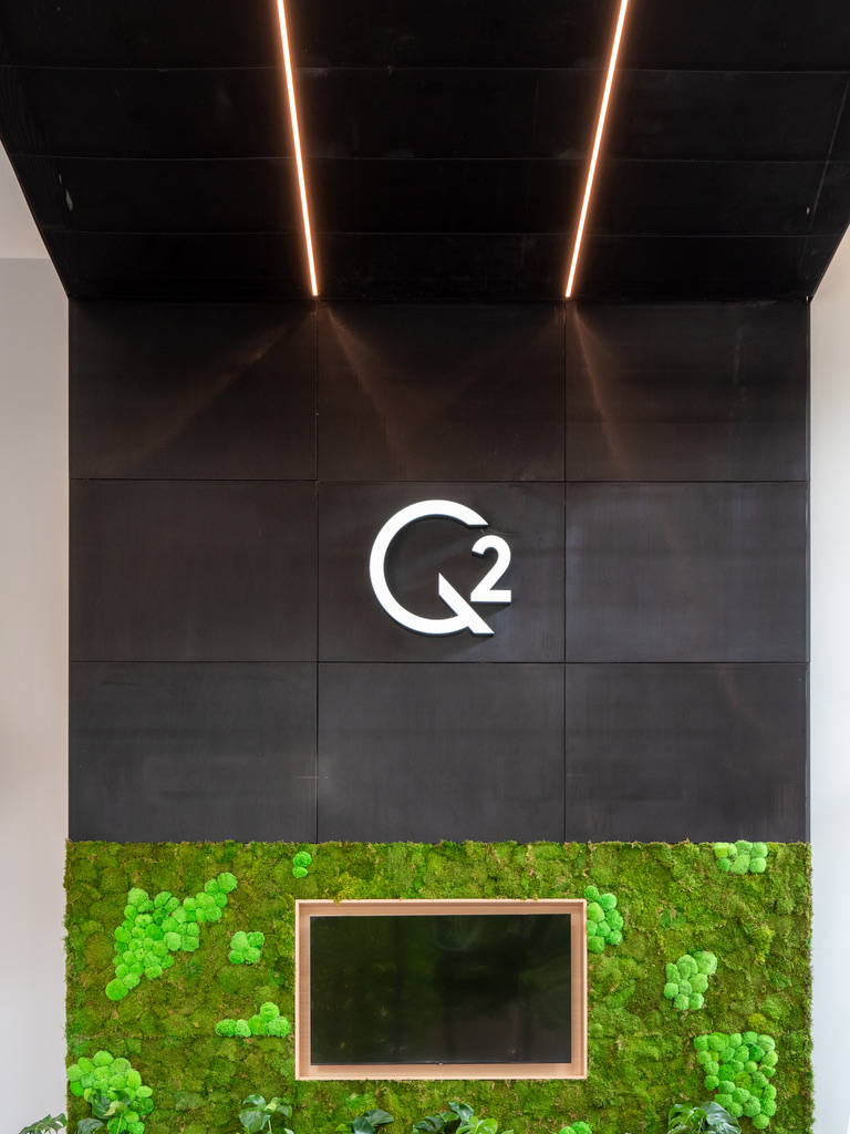 2 Whitehall Quay — Q2 branded feature wall with linear LED ceiling tracks and moss wall