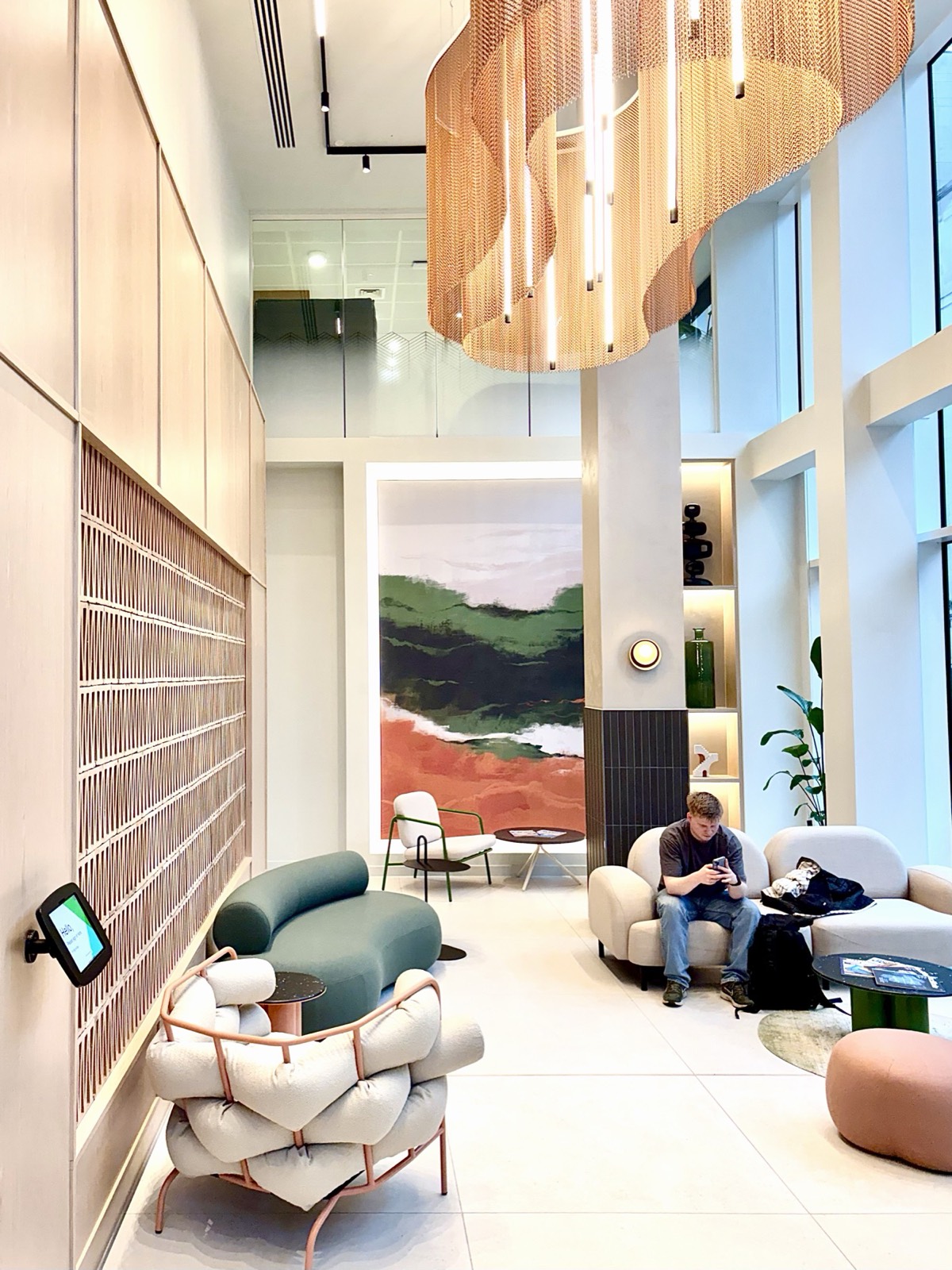7 Park Row — double-height reception lounge with Aqform Piper suspended luminaires in the copper centrepiece and boucle seating