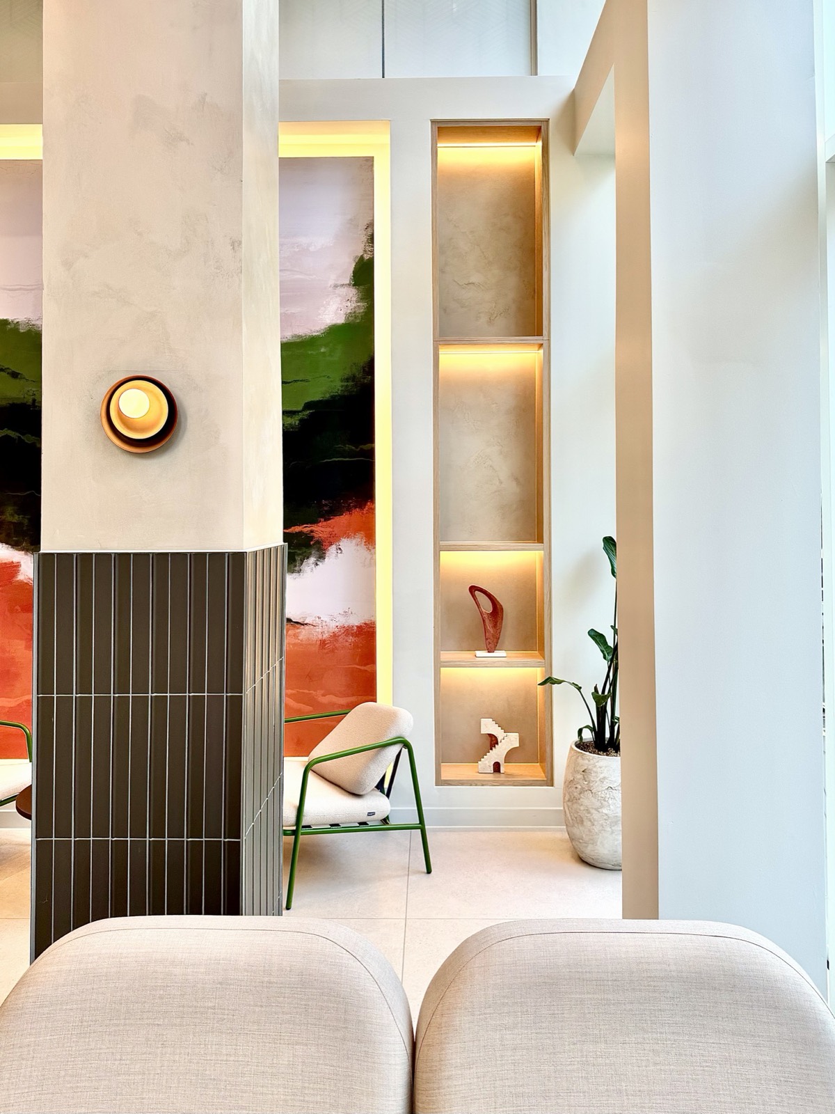 7 Park Row — plastered column with brass wall light and warmly lit display niches
