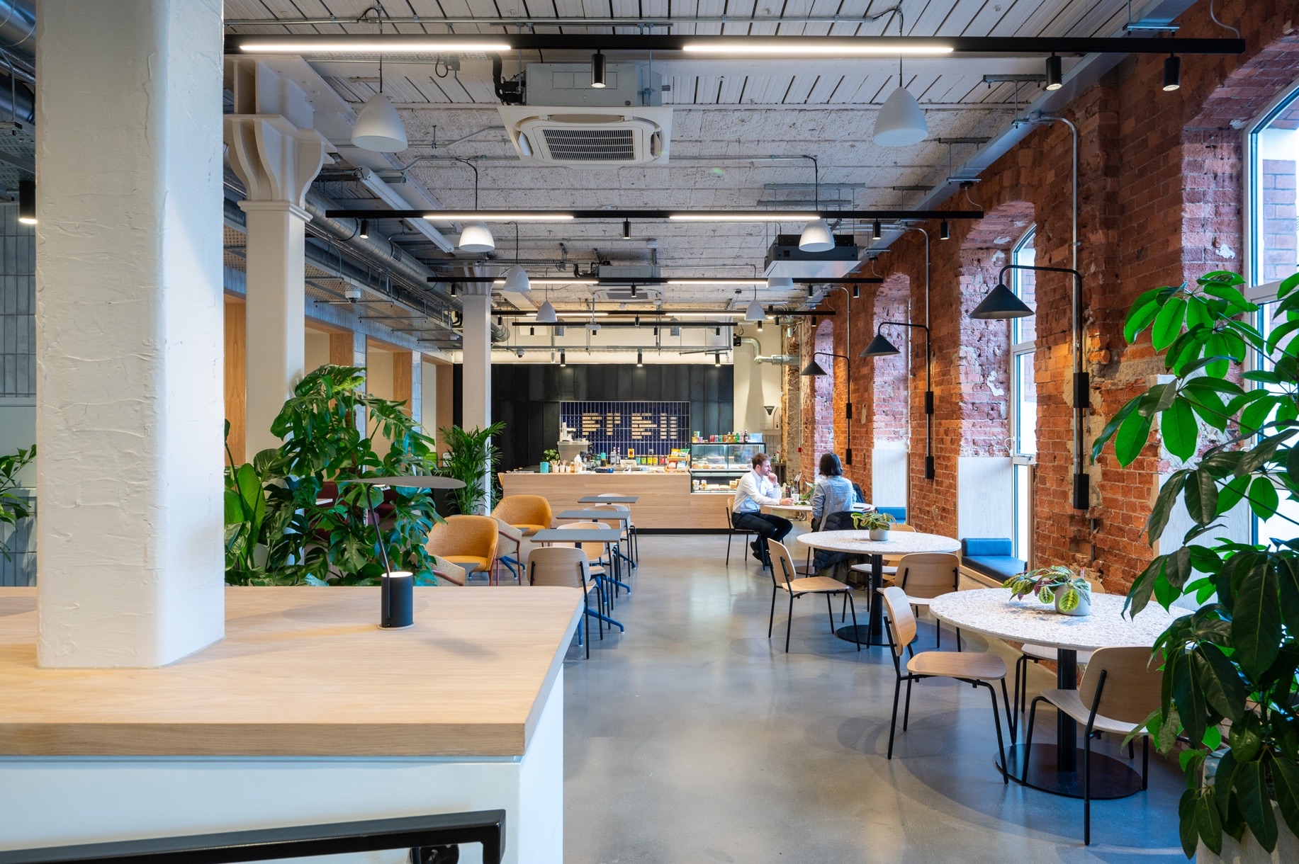 The Centro Buildings — café and breakout space with Aqform linear track lighting, exposed brick and planted touchdown areas