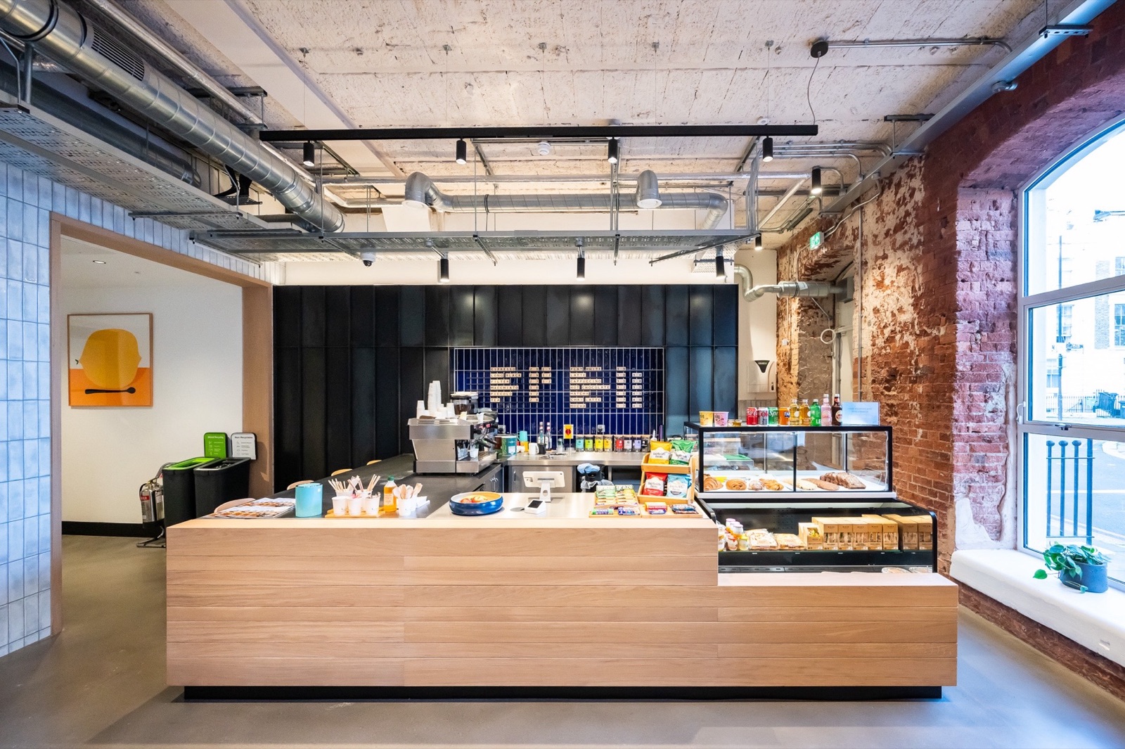 The Centro Buildings — café counter with Aqform surface-mounted spots and exposed brick feature wall
