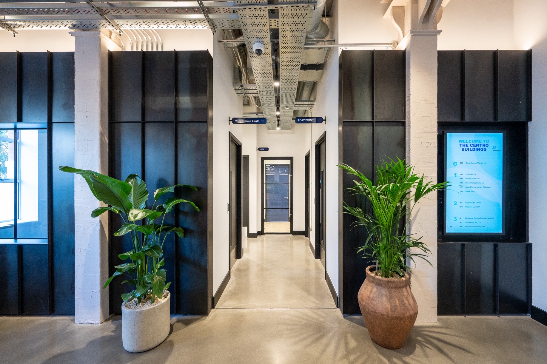 The Centro Buildings — communal corridor with directory board and Aqform linear track lighting