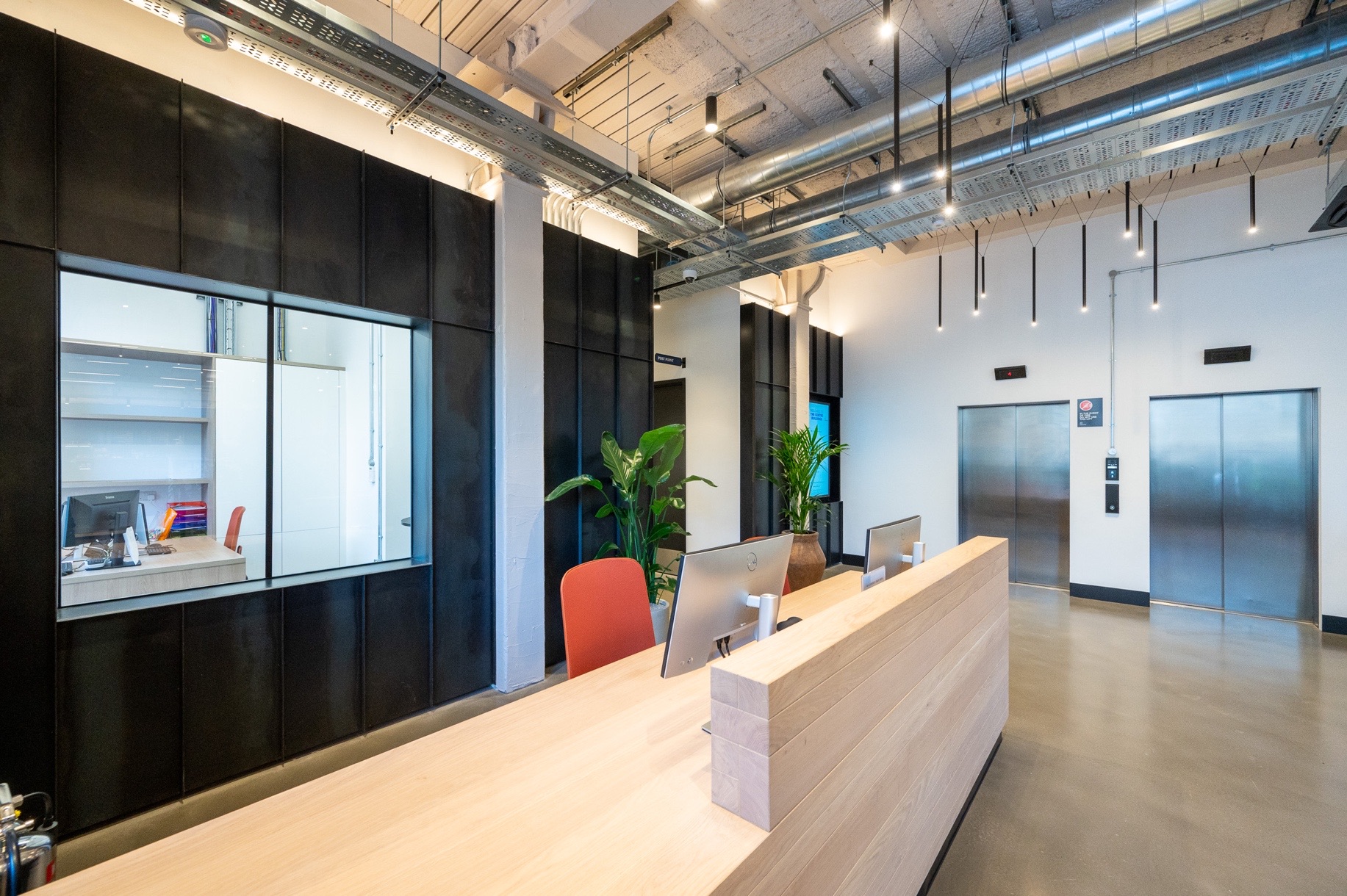 The Centro Buildings — reception desk close-up with Zava Luce pendant lighting above