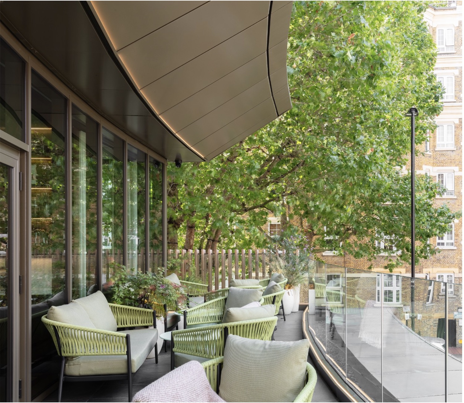 Restaurant Story — upper-level cocktail balcony with linear LED soffit lighting, Zava Luce planter lights and cantilevered canopy