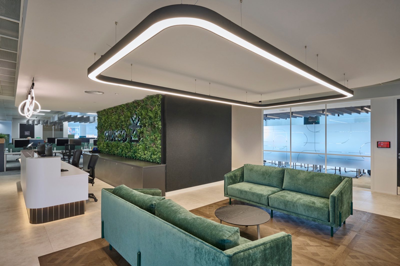 Bespoke curved rectangle of Lightforms Serpentine linear lighting suspended over the reception lounge