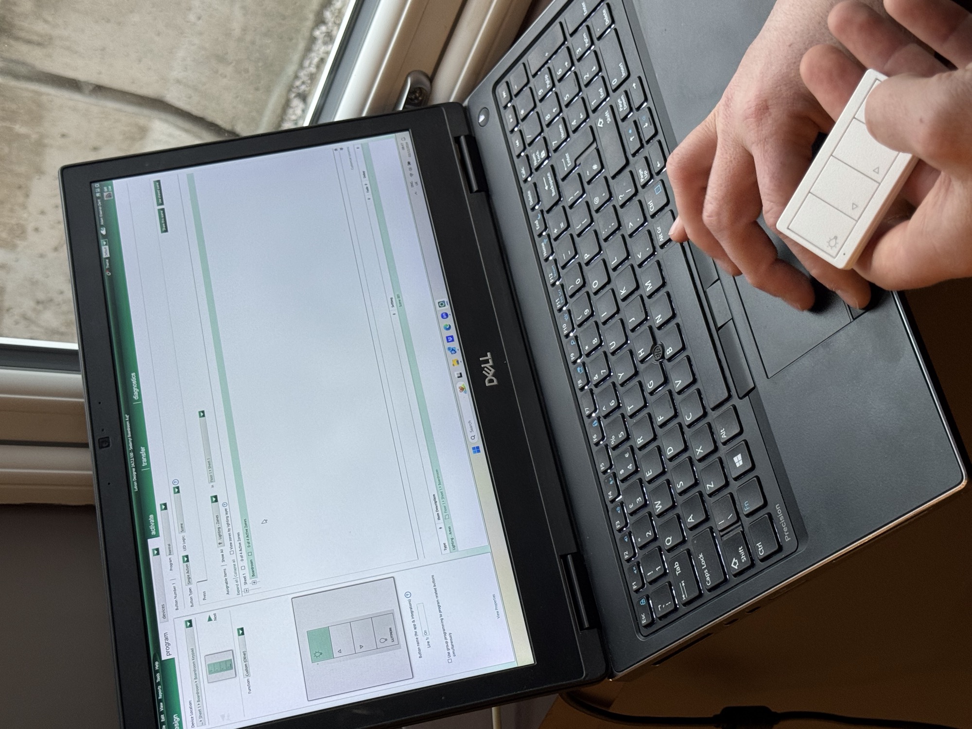 Engineer programming a Lutron Athena keypad from a laptop during on-site commissioning