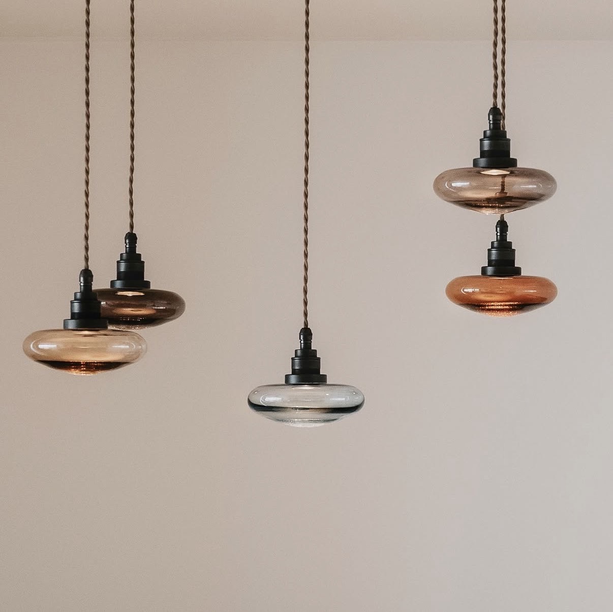 Group of mouth-blown glass pendants in amber and smoke tones
